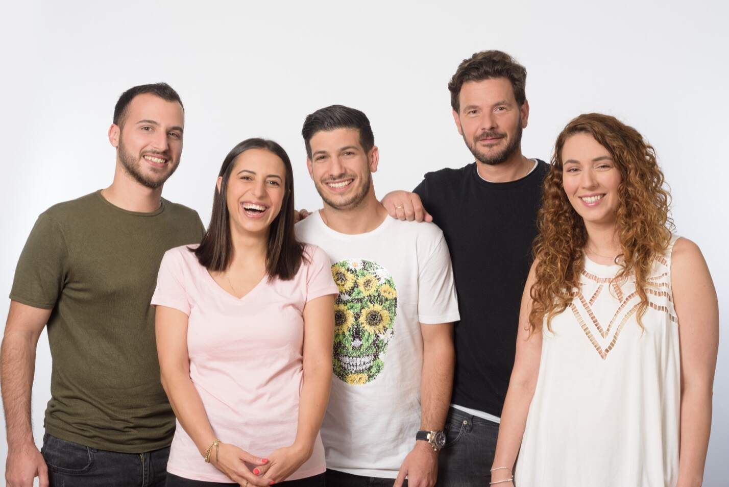 חמישה אנשים מחייכים, עומדים זה לצד זה מול רקע לב